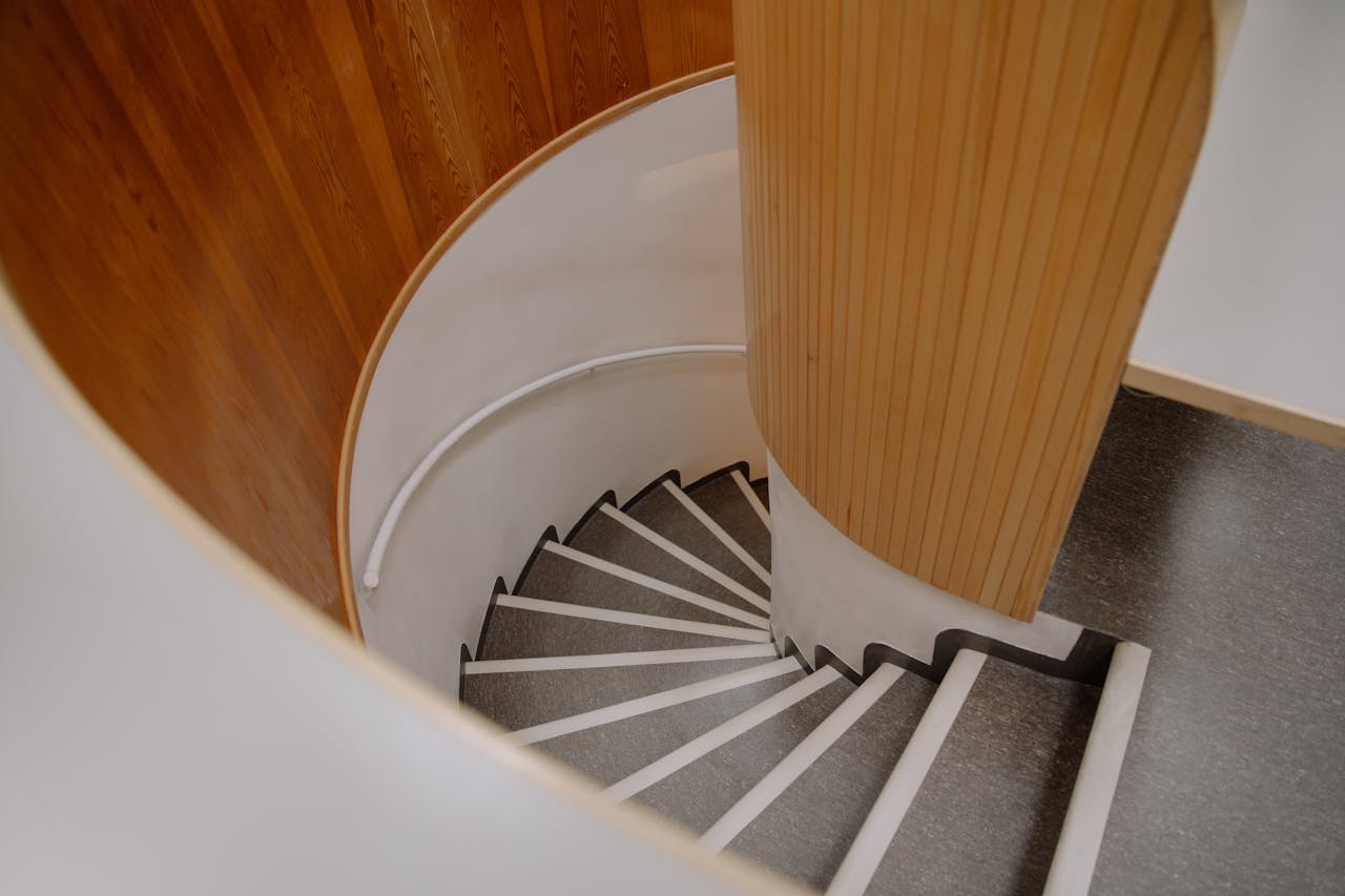 A top view of a modern spiral staircase with sleek wooden panels and a minimalist design.